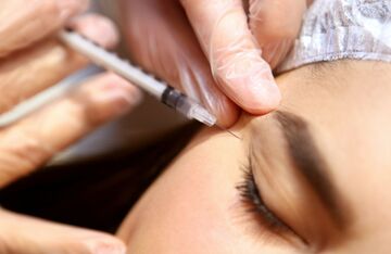 person receiving botox injections near eye